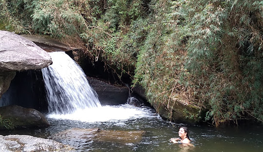 Cachoeira no meio de um rio Descrição gerada automaticamente