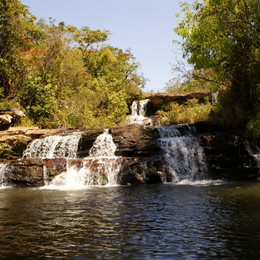 Cachoeira no meio de um rio Descrição gerada automaticamente com confiança média