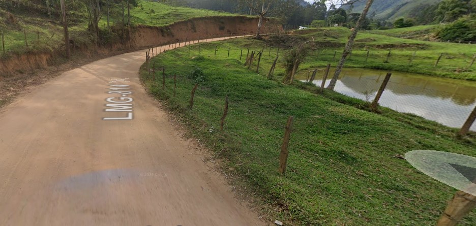 Caminho de terra com grama ao lado de uma estrada Descrição gerada automaticamente