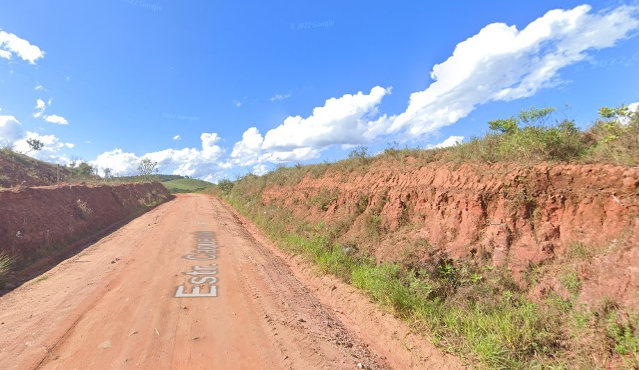Caminho de terra com montanha ao fundo Descrição gerada automaticamente