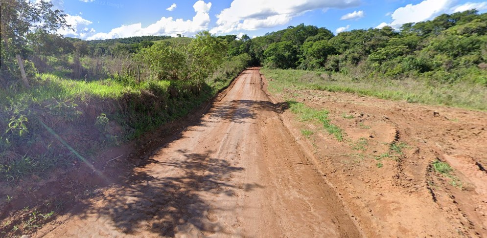 Caminho de terra com montanha ao fundo Descrição gerada automaticamente