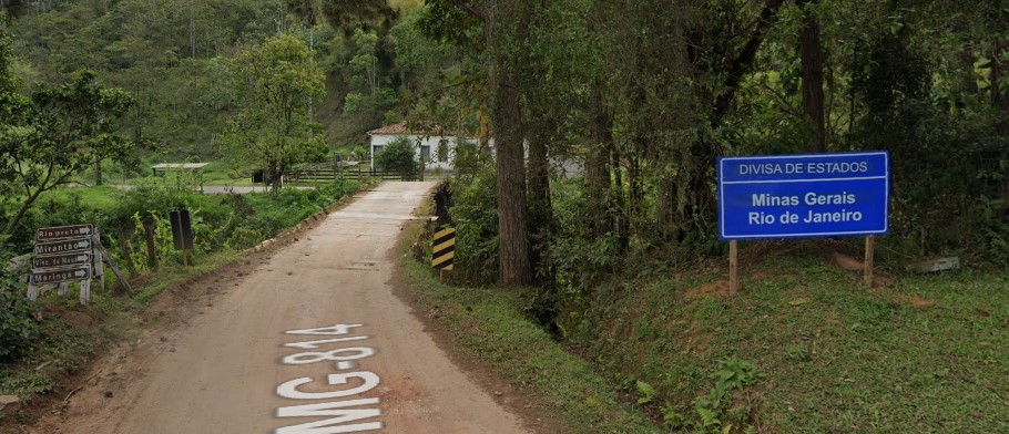 Caminho de terra do lado de uma placa Descrição gerada automaticamente