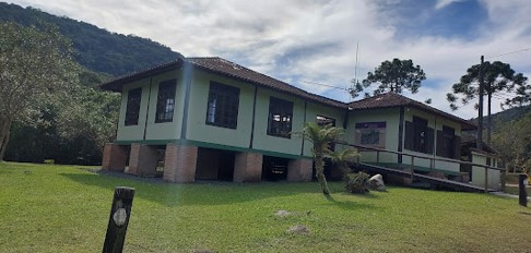Casa com gramado na frente Descrição gerada automaticamente
