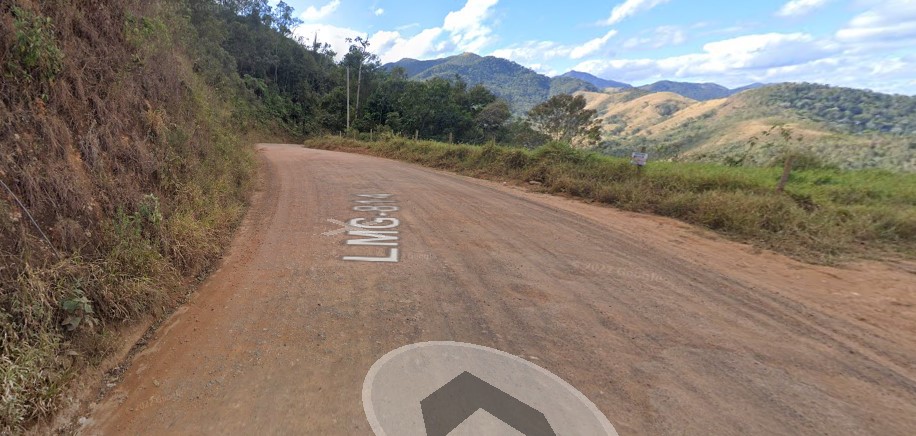 Estrada de terra com montanha ao fundo Descrição gerada automaticamente