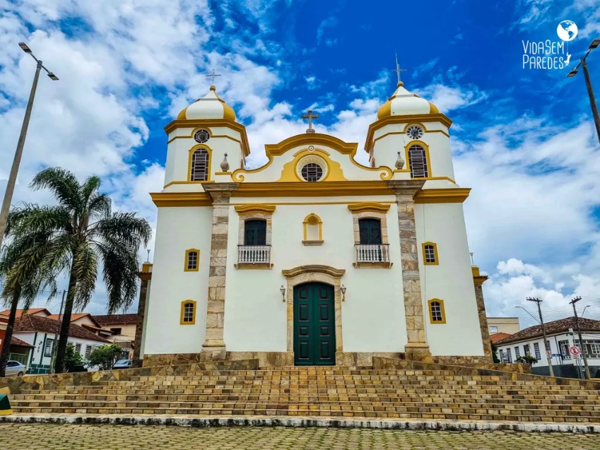 Igreja com torre alta ao fundo Descrição gerada automaticamente