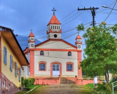 Igreja em frente a casa Descrição gerada automaticamente