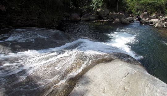 Rio com pedras Descrição gerada automaticamente com confiança média