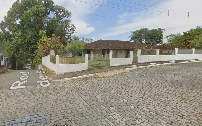 Rua com casas e árvores Descrição gerada automaticamente com confiança média